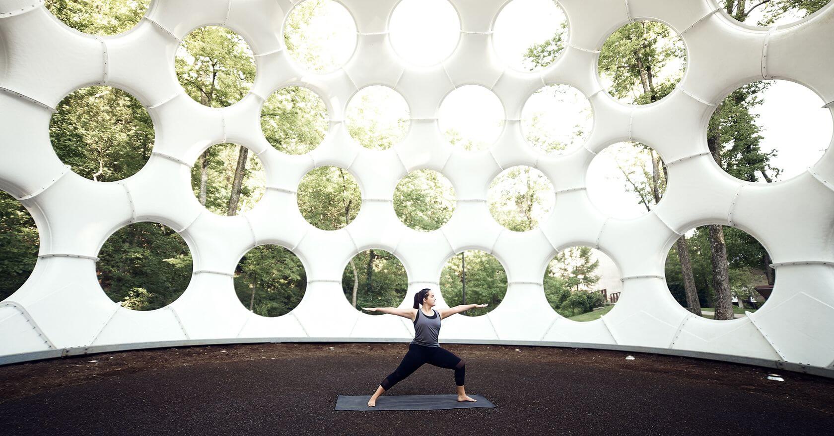 woman doing yoga inside sculpture in bentonville arkansas